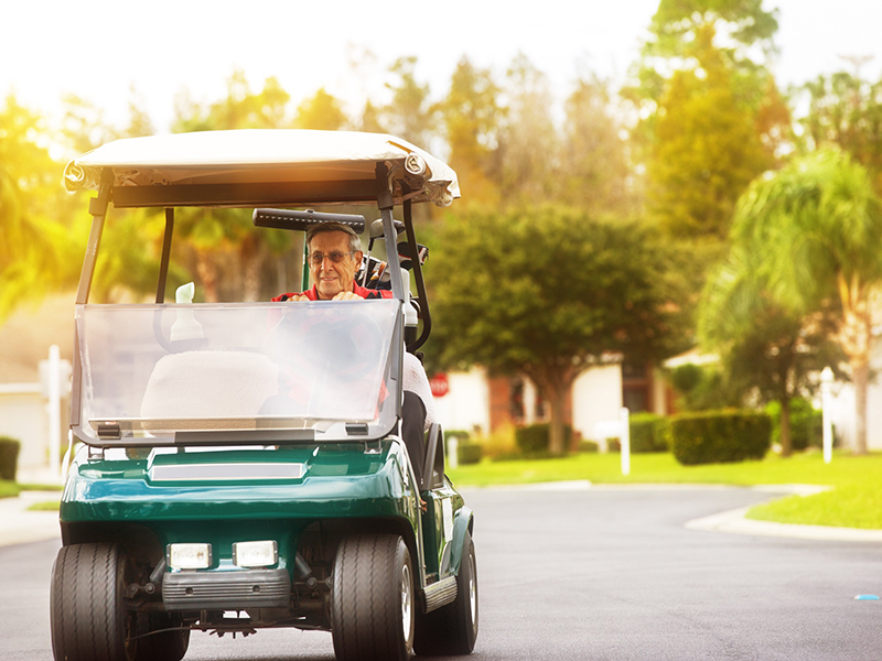 senior riding a golf cart